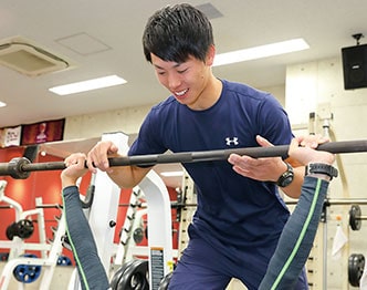 トレーニングする選手のコンディションを確認するトレーナー