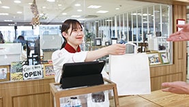 袋を手渡す学生
