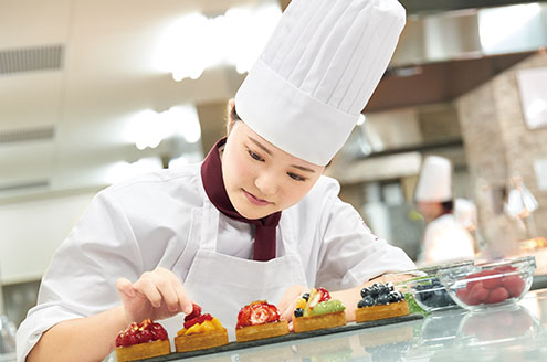 ケーキのデコレーションをする学生